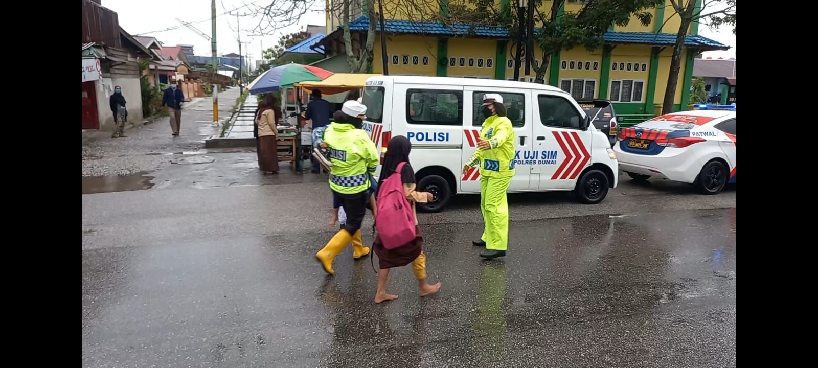 Salut ! Aksi Saat  Banjir dan Hujan, Kasat Lantas Polres Dumai Rela Dorong Motor dan Seberangkan Pelajar Sekolah