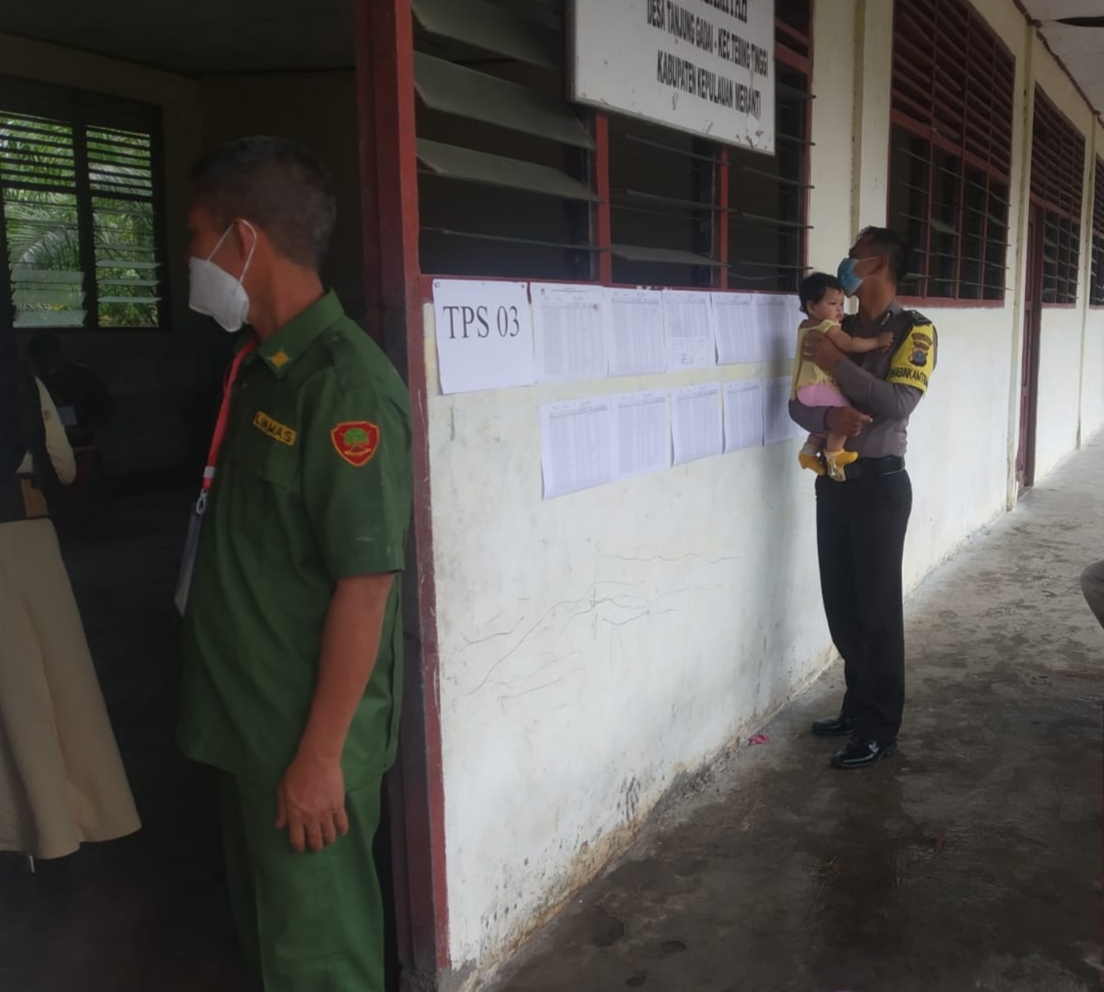 Polisi di Kepulauan Meranti Bantu Gendong Bayi Saat Ibunya Nyoblos Pilkades di TPS