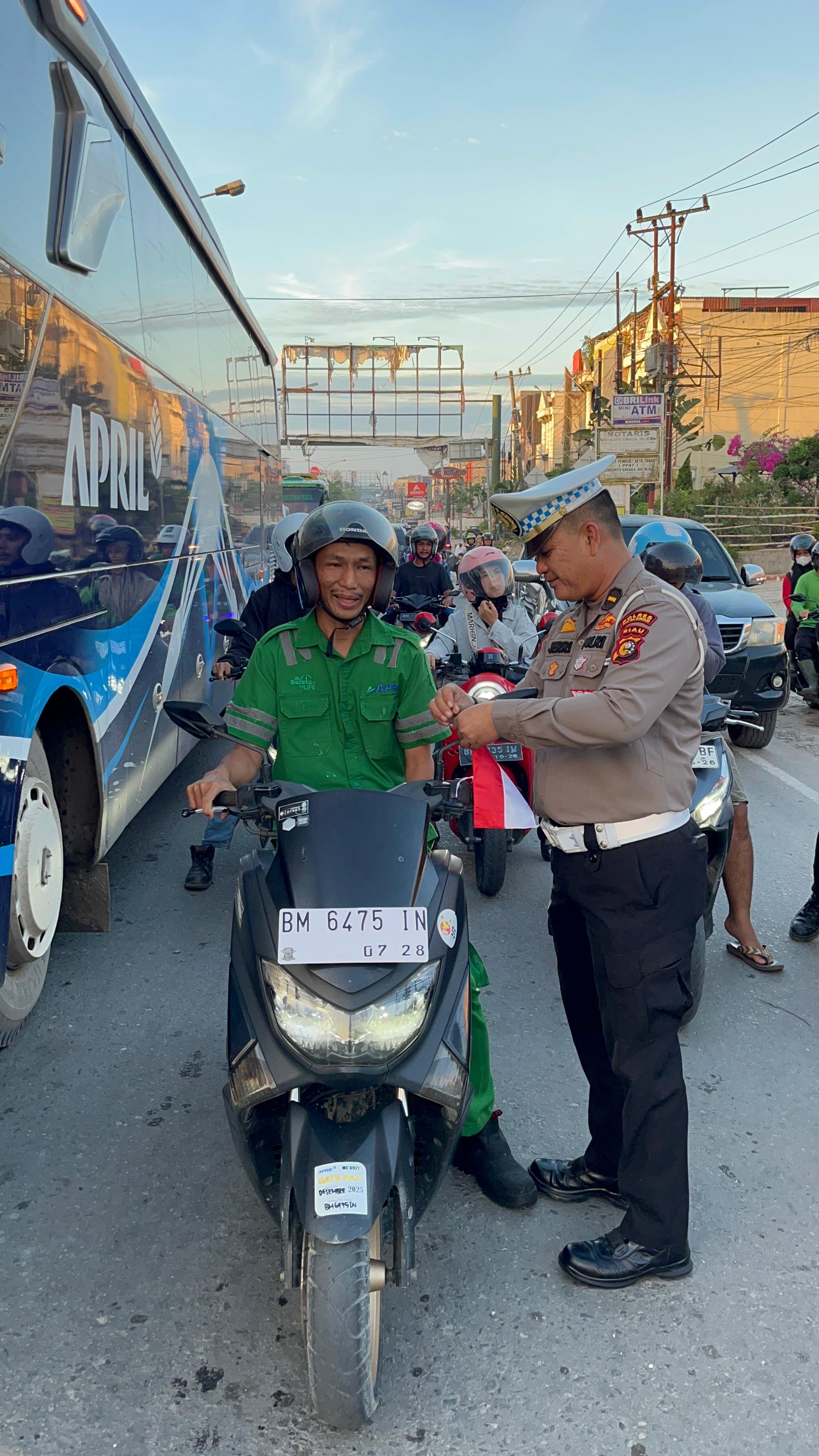 Satlantas Polres Pelalawan Tebar Semangat Proklamasi, Bagikan Ratusan Bendera Merah Putih di Jalan Lintas Timur